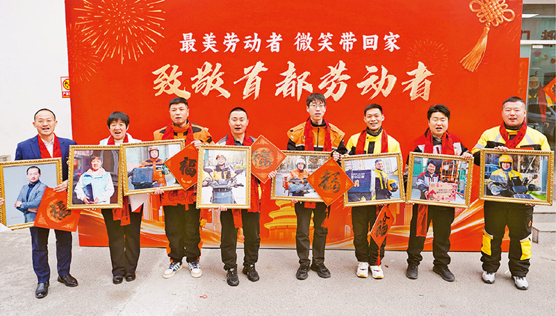 2026年2月6日，中华全国总工会在北京CBD骑士驿站举办2026年“送文化·惠职工”专项行动启动仪式暨“迎新春·送万福”职工书法公益活动新业态劳动者专场。图为劳模工匠代表展示工会赠送的专属“最美微笑照”。